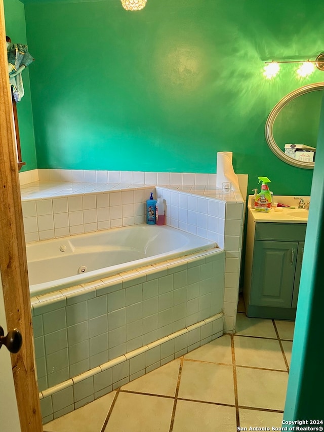 bathroom featuring tile patterned flooring, vanity, and tiled tub