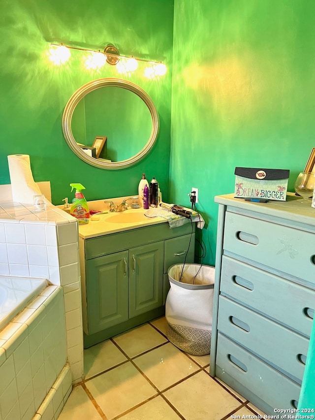 bathroom featuring vanity, a relaxing tiled tub, and tile patterned flooring