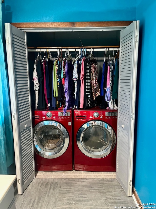 laundry area featuring washing machine and clothes dryer and light hardwood / wood-style floors