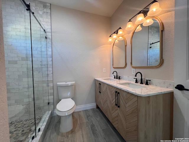 bathroom with vanity, toilet, hardwood / wood-style flooring, and a shower with shower door