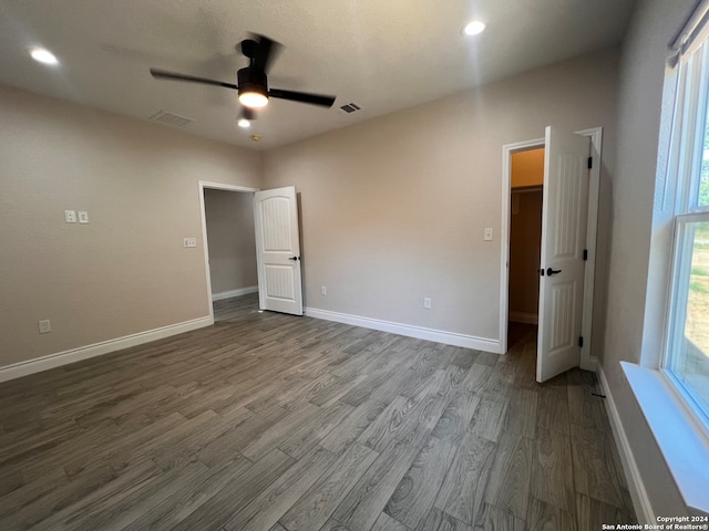 interior space with dark wood-type flooring, ceiling fan, and a spacious closet