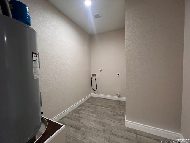 clothes washing area featuring hookup for a washing machine, hardwood / wood-style floors, hookup for an electric dryer, and water heater