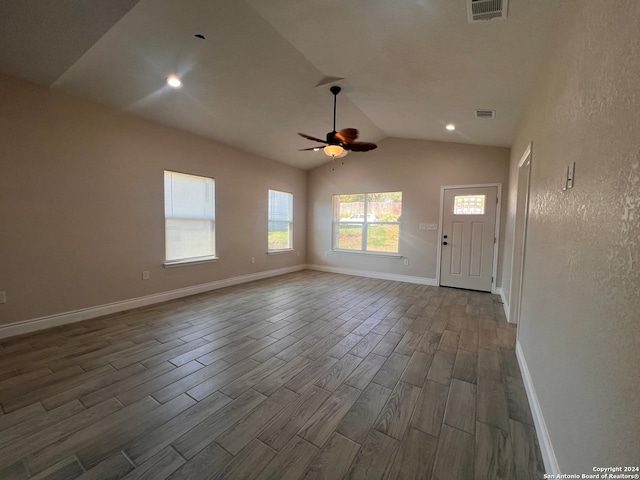 unfurnished living room with dark wood-type flooring, ceiling fan, and vaulted ceiling