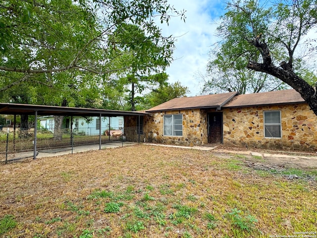 ranch-style house featuring a carport and a front lawn