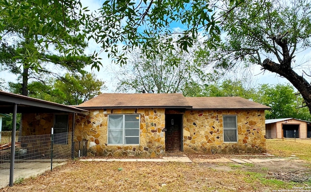 ranch-style home featuring an outbuilding