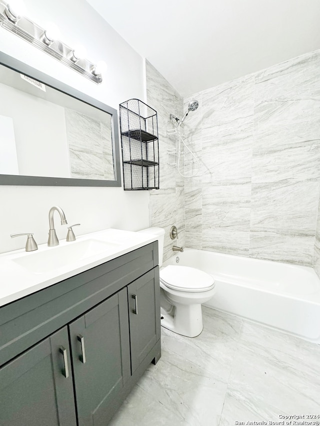 full bathroom with tiled shower / bath, vanity, toilet, and vaulted ceiling