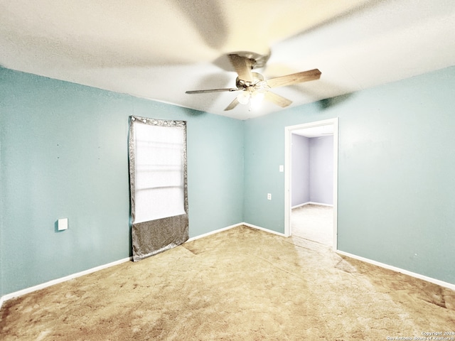 carpeted empty room with ceiling fan and a textured ceiling