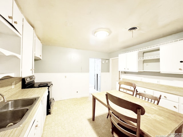 kitchen featuring sink, stainless steel electric range oven, and white cabinetry