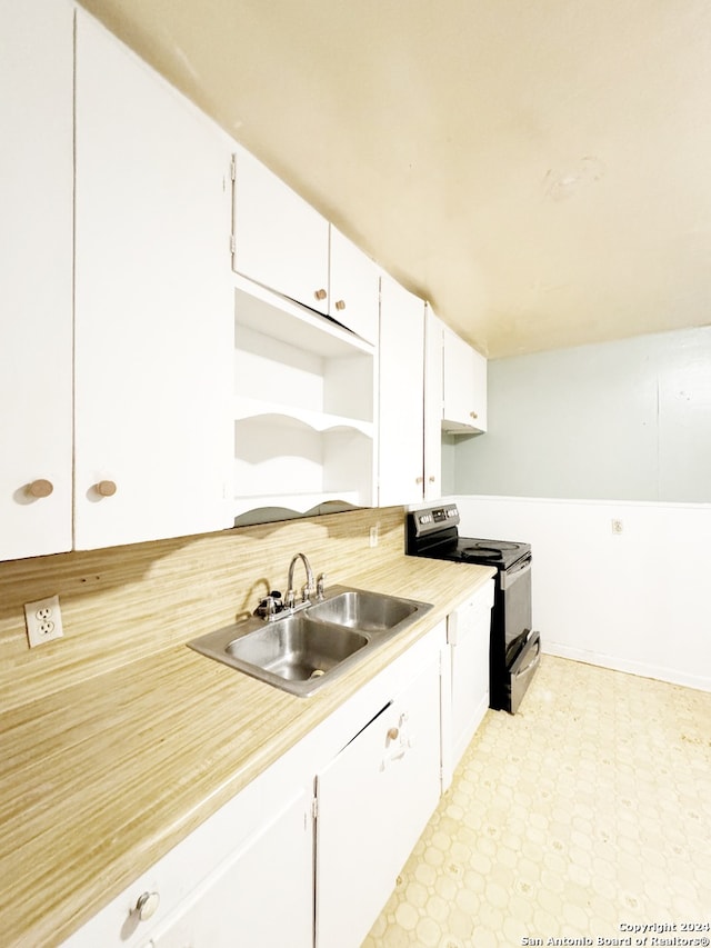 kitchen featuring sink, stainless steel electric range oven, and white cabinets