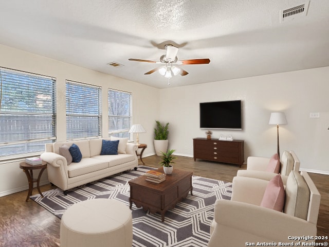 living room with ceiling fan, wood-type flooring, and a textured ceiling