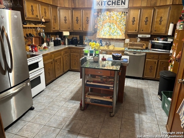 kitchen featuring a center island, light tile patterned floors, and stainless steel appliances