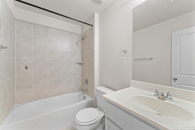 full bathroom featuring tiled shower / bath, toilet, a textured ceiling, and vanity