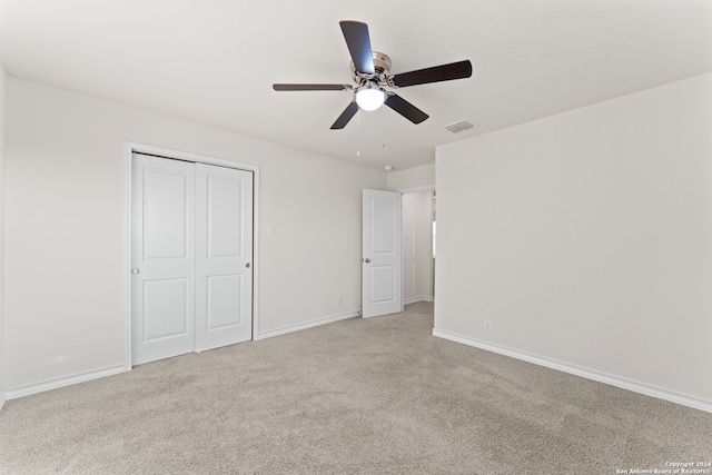 unfurnished bedroom with light carpet, ceiling fan, and a closet