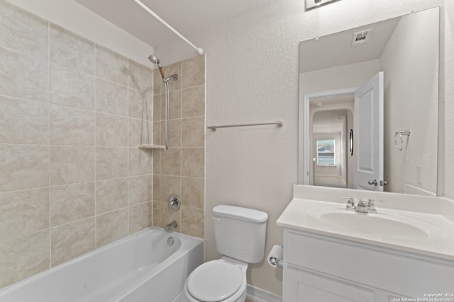 full bathroom with tiled shower / bath combo, vanity, and toilet