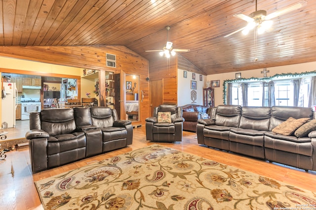 living room featuring lofted ceiling, ceiling fan, wooden walls, and wooden ceiling