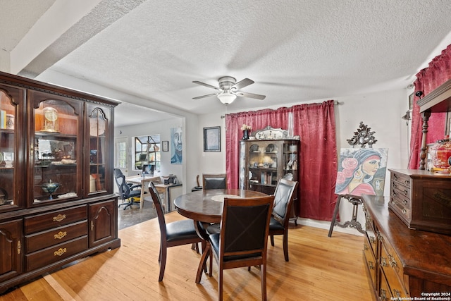 dining room featuring a textured ceiling, ceiling fan, and light hardwood / wood-style flooring