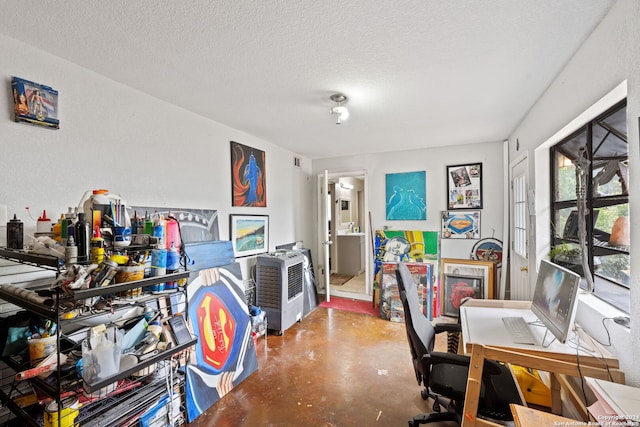 home office featuring a textured ceiling and concrete flooring