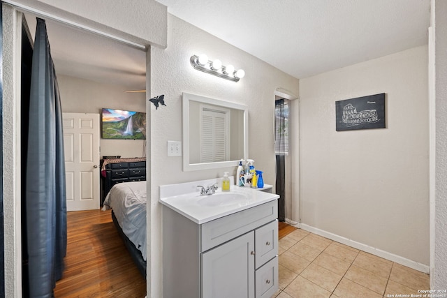 bathroom featuring a textured ceiling, tile patterned floors, and vanity