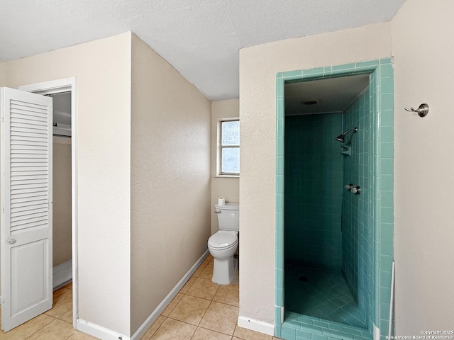 bathroom featuring toilet, a textured ceiling, tile patterned floors, and tiled shower