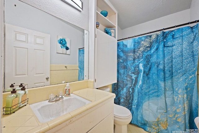 bathroom with toilet, a textured ceiling, and vanity