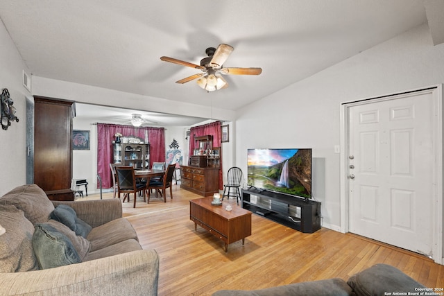 living room with ceiling fan, vaulted ceiling, and light hardwood / wood-style flooring