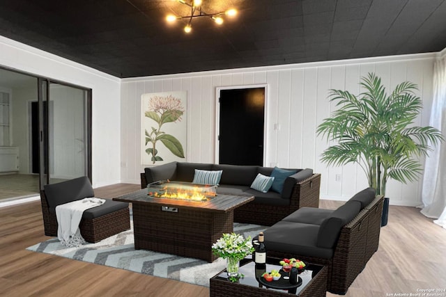 living room with ornamental molding, wood-type flooring, and a chandelier