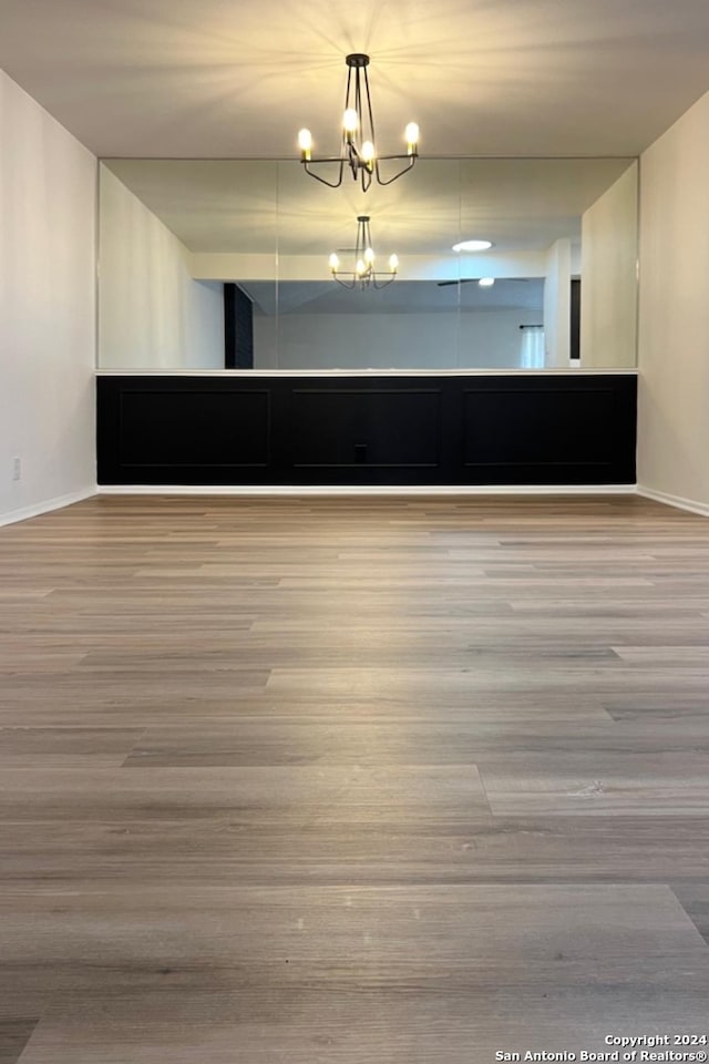 spare room featuring hardwood / wood-style floors and a notable chandelier