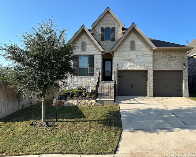 french country style house with a front lawn and a garage