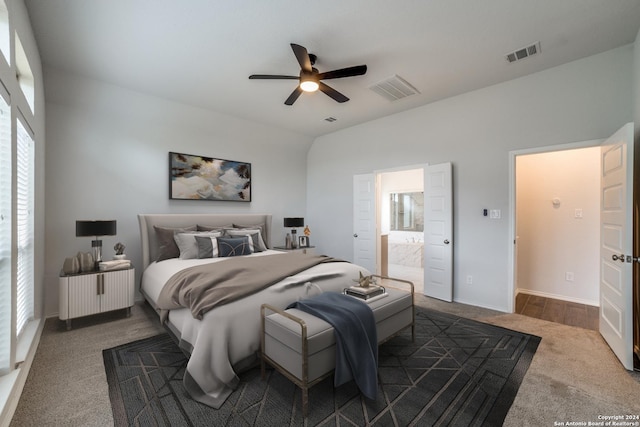 carpeted bedroom with visible vents, ensuite bath, and ceiling fan