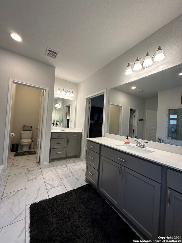 bathroom featuring vanity, toilet, and a textured ceiling