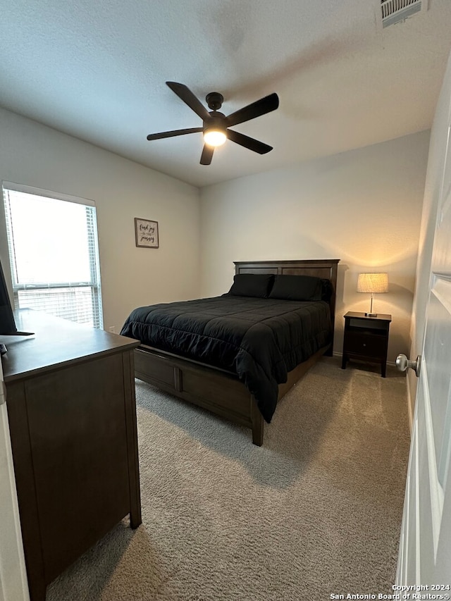 bedroom featuring light colored carpet and ceiling fan