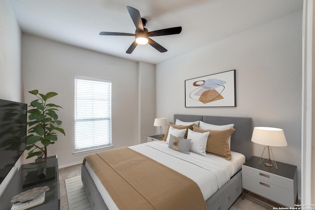 bedroom featuring baseboards, light colored carpet, and ceiling fan