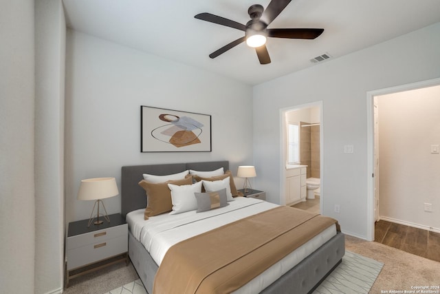 bedroom featuring visible vents, light carpet, a ceiling fan, connected bathroom, and baseboards