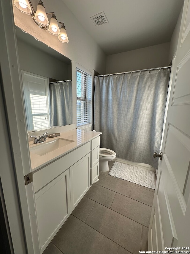 bathroom featuring toilet, a shower with curtain, vanity, and tile patterned flooring