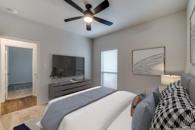 bedroom with baseboards, wood finished floors, carpet, and ceiling fan