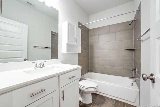 full bathroom featuring vanity, wood finished floors, visible vents, tub / shower combination, and toilet