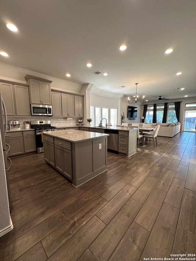 kitchen featuring gray cabinetry, stainless steel appliances, kitchen peninsula, and dark hardwood / wood-style floors