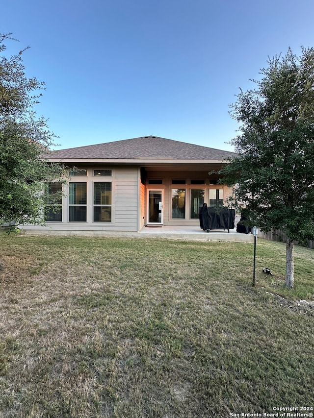 back of house with a yard and a patio