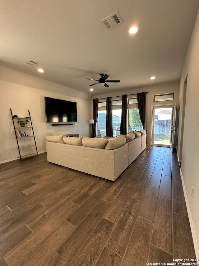 unfurnished living room featuring ceiling fan and dark hardwood / wood-style flooring