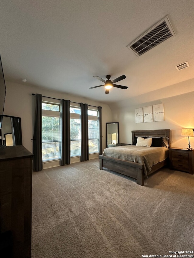 carpeted bedroom with ceiling fan and a textured ceiling