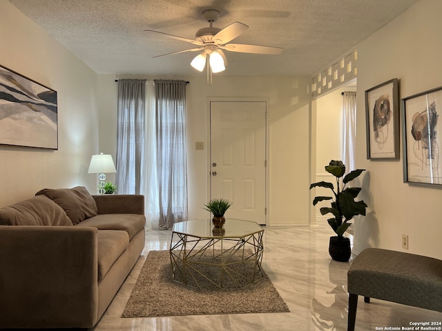 living room with a textured ceiling and ceiling fan