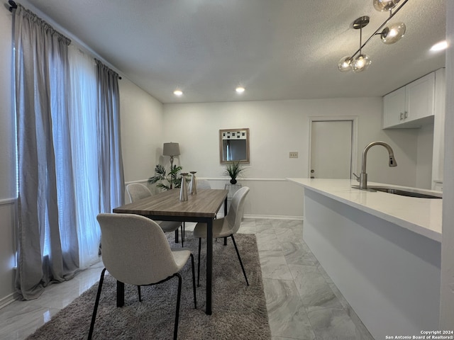 dining area with a textured ceiling and sink