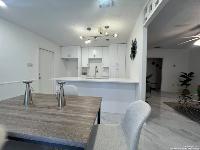 dining room with ceiling fan, a textured ceiling, and sink