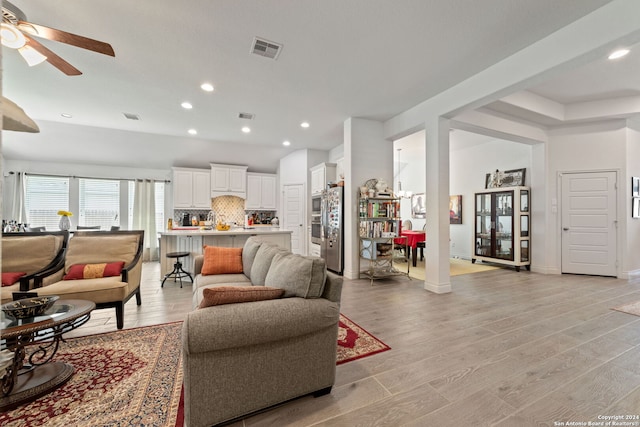 living room featuring ceiling fan and light hardwood / wood-style floors