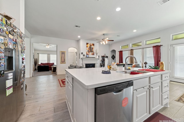 kitchen with appliances with stainless steel finishes, an island with sink, a wealth of natural light, ceiling fan, and white cabinets