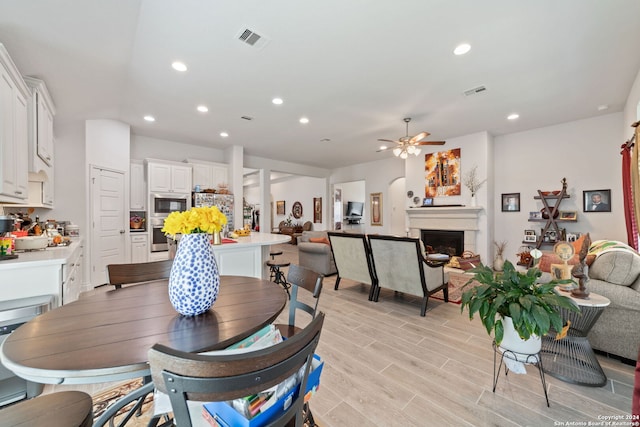 dining area with ceiling fan and light hardwood / wood-style floors