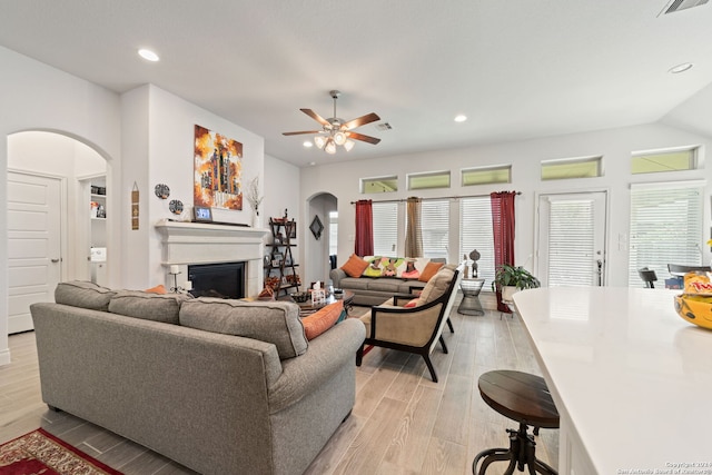 living room with ceiling fan, vaulted ceiling, and light hardwood / wood-style flooring