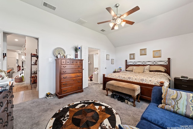 bedroom with lofted ceiling, ceiling fan, light carpet, and ensuite bath