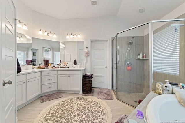 bathroom with vanity, vaulted ceiling, hardwood / wood-style floors, and shower with separate bathtub