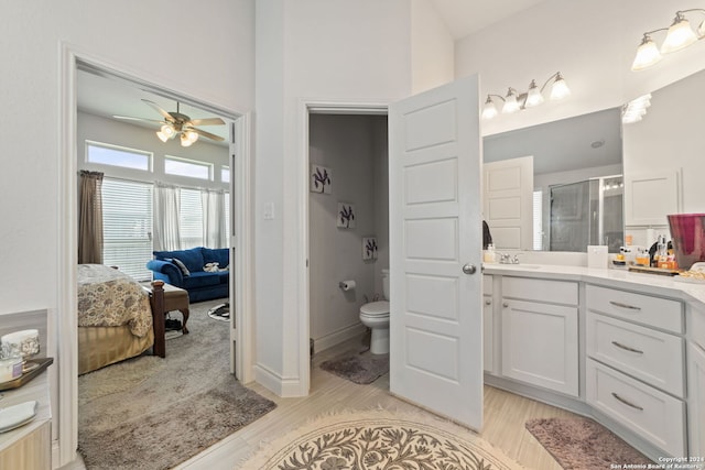 bathroom featuring toilet, an enclosed shower, vanity, ceiling fan, and hardwood / wood-style flooring